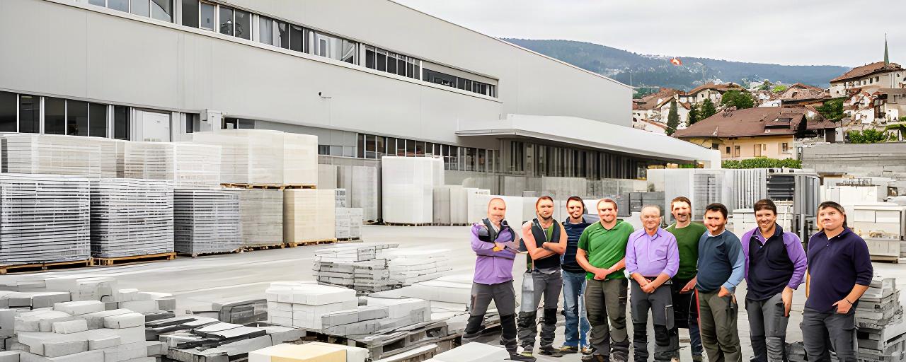 Mitarbeitende vor einem Baustoffwerk in Bern mit Betonprodukten im Vordergrund